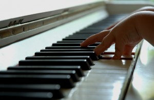 child hands play piano